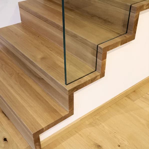 Detail von Holzstufen mit Glasgeländer