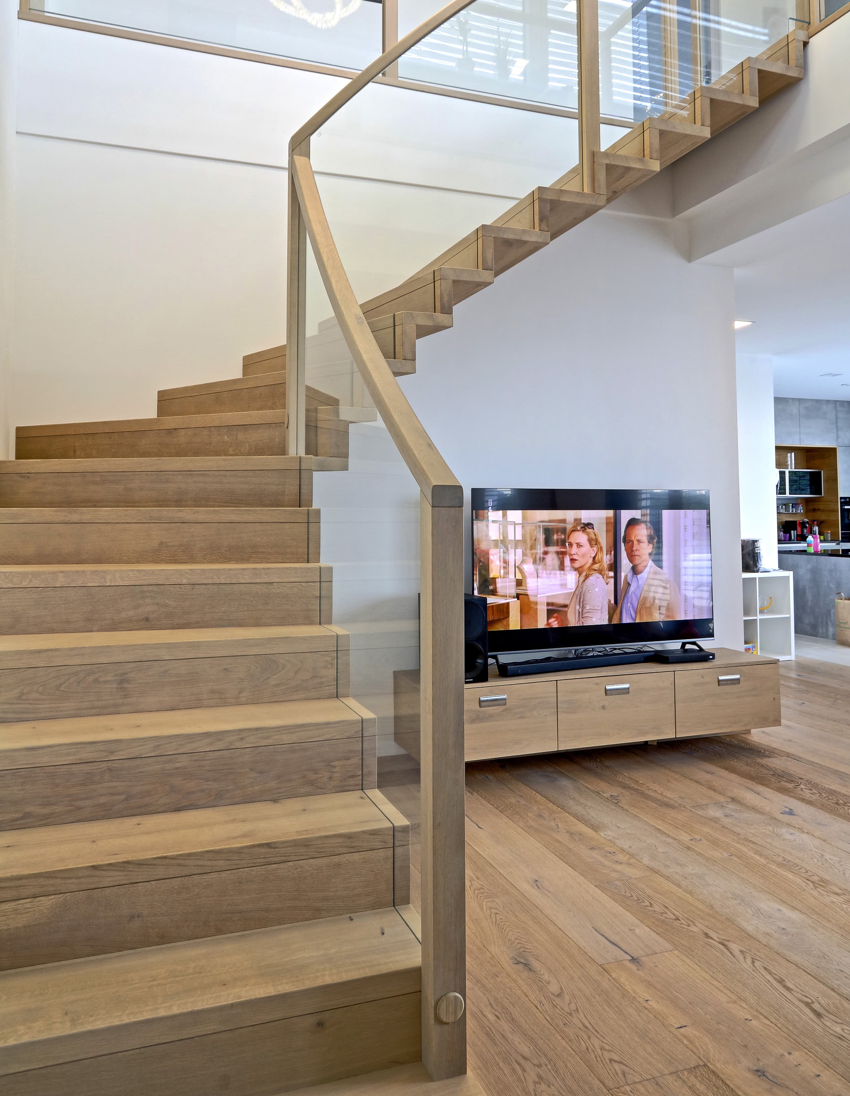 Geschwungene Holztreppe mit Glasgeländer - Bild 1