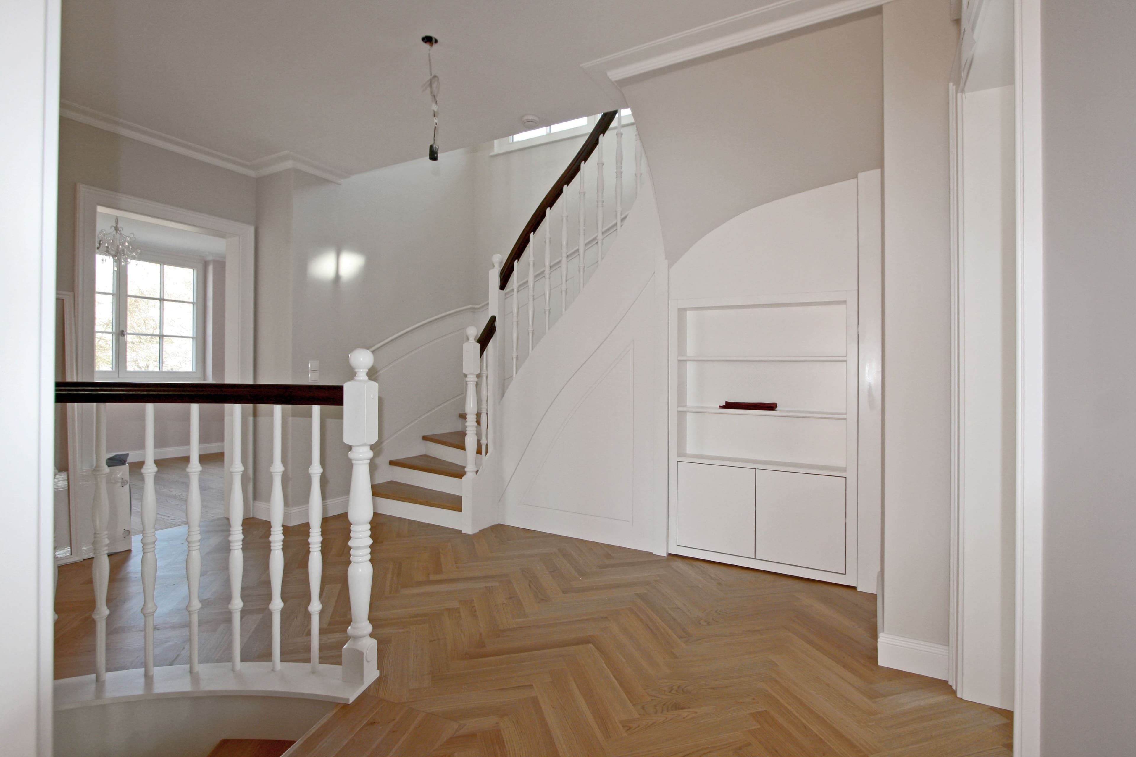 Geschwungene Betonstiege mit Massivholzstufen und klassischem Geländer - Bild 4