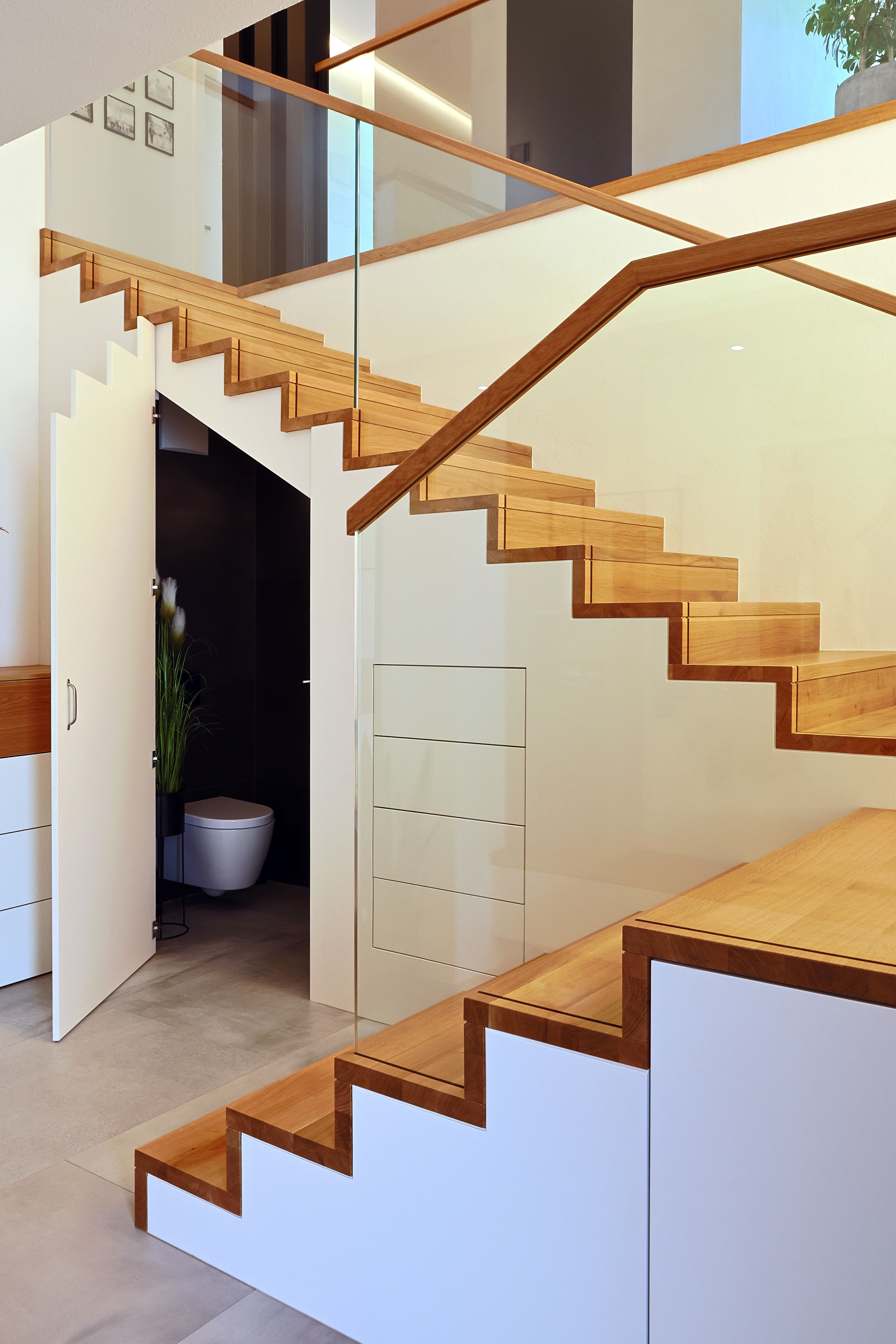 Betonstiege mit Eichenstufen und Glasgeländer