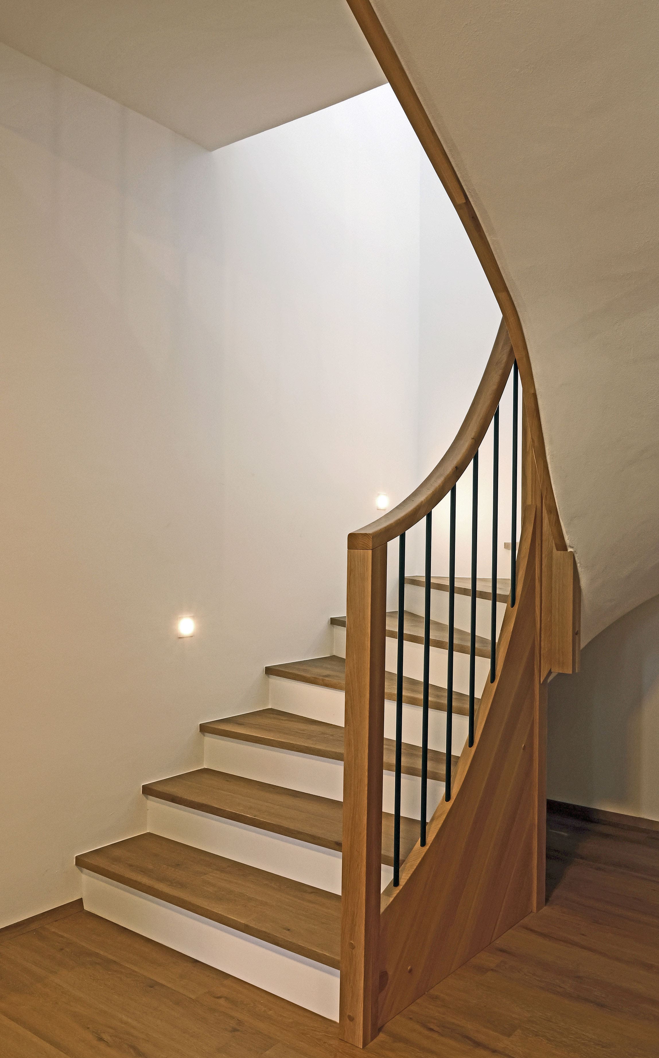 Geschwungene Betonstiege mit Holzauftritten und Holzgeländer - Bild 2