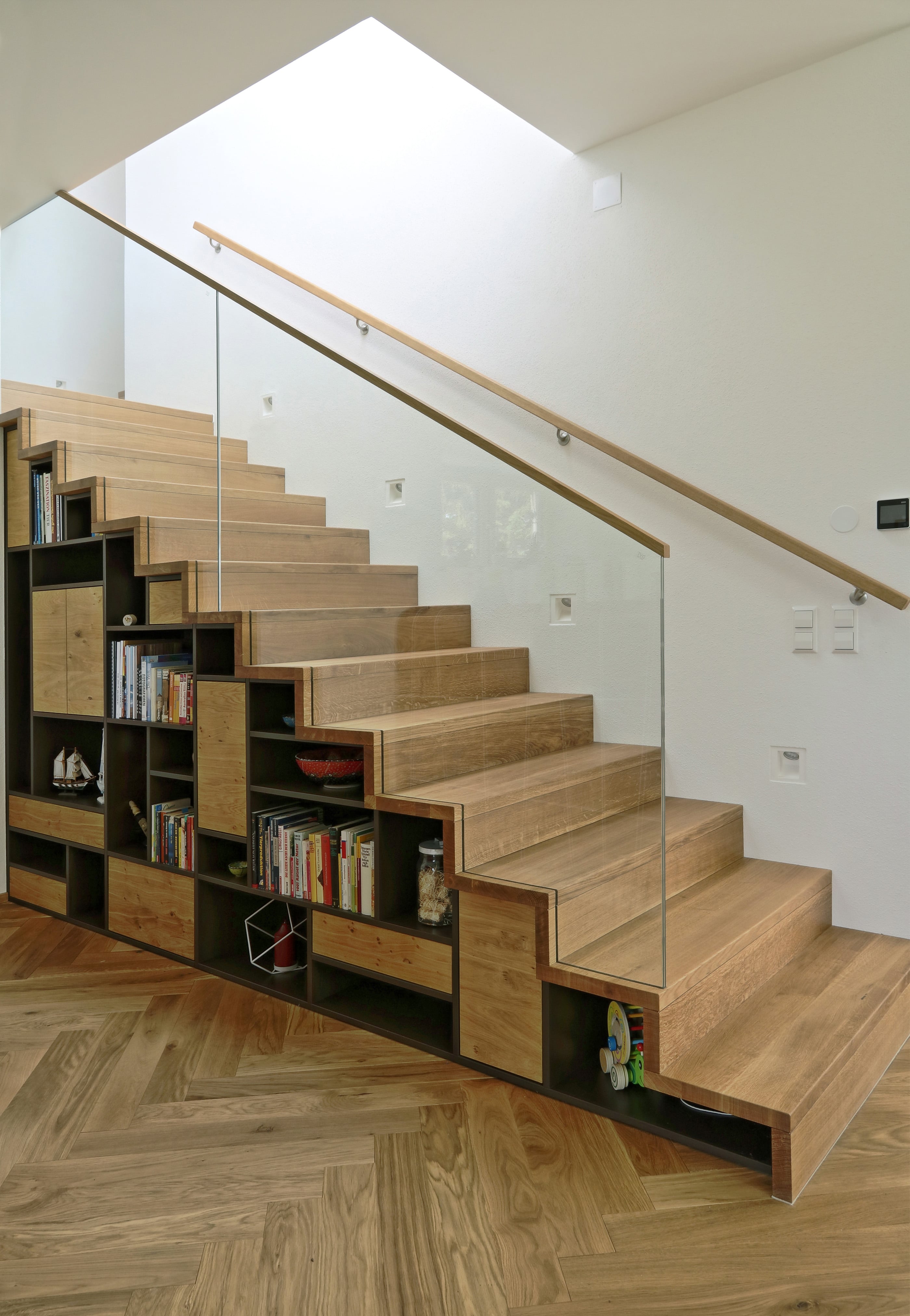 Holztreppe mit Stauraum und Glasgeländer