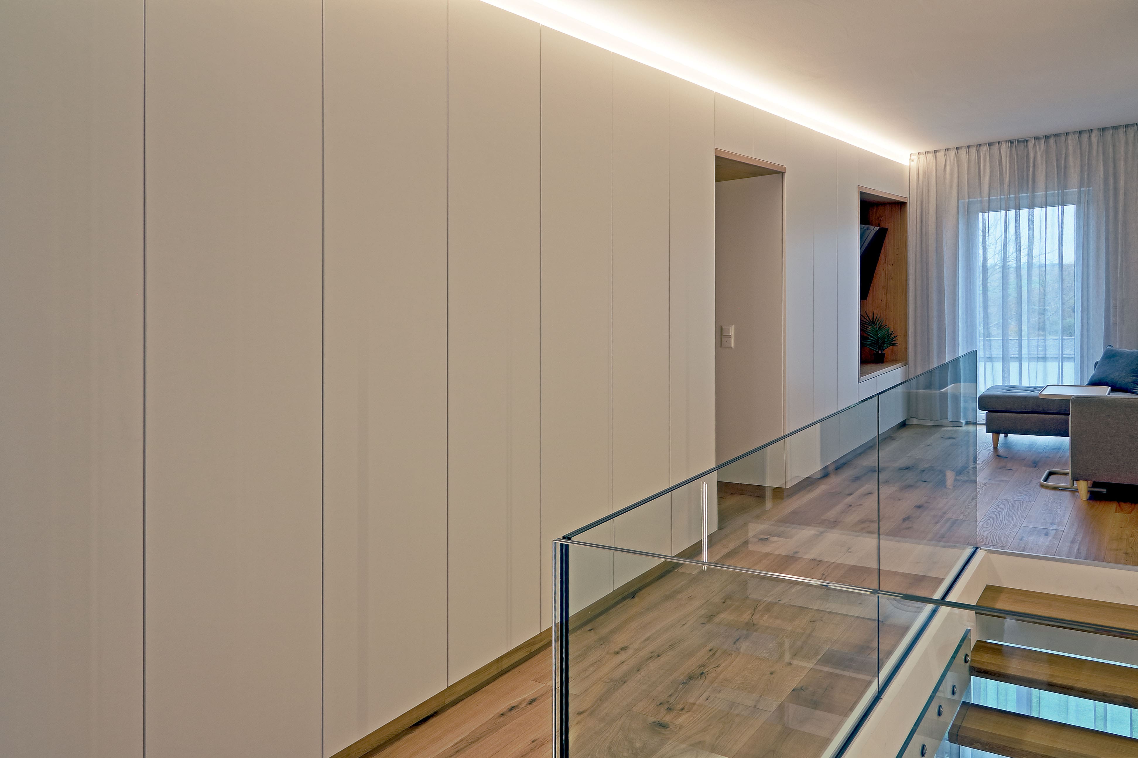 Moderne freitragende Holztreppe mit Glasgeländer und Lichtakzenten - Bild 6