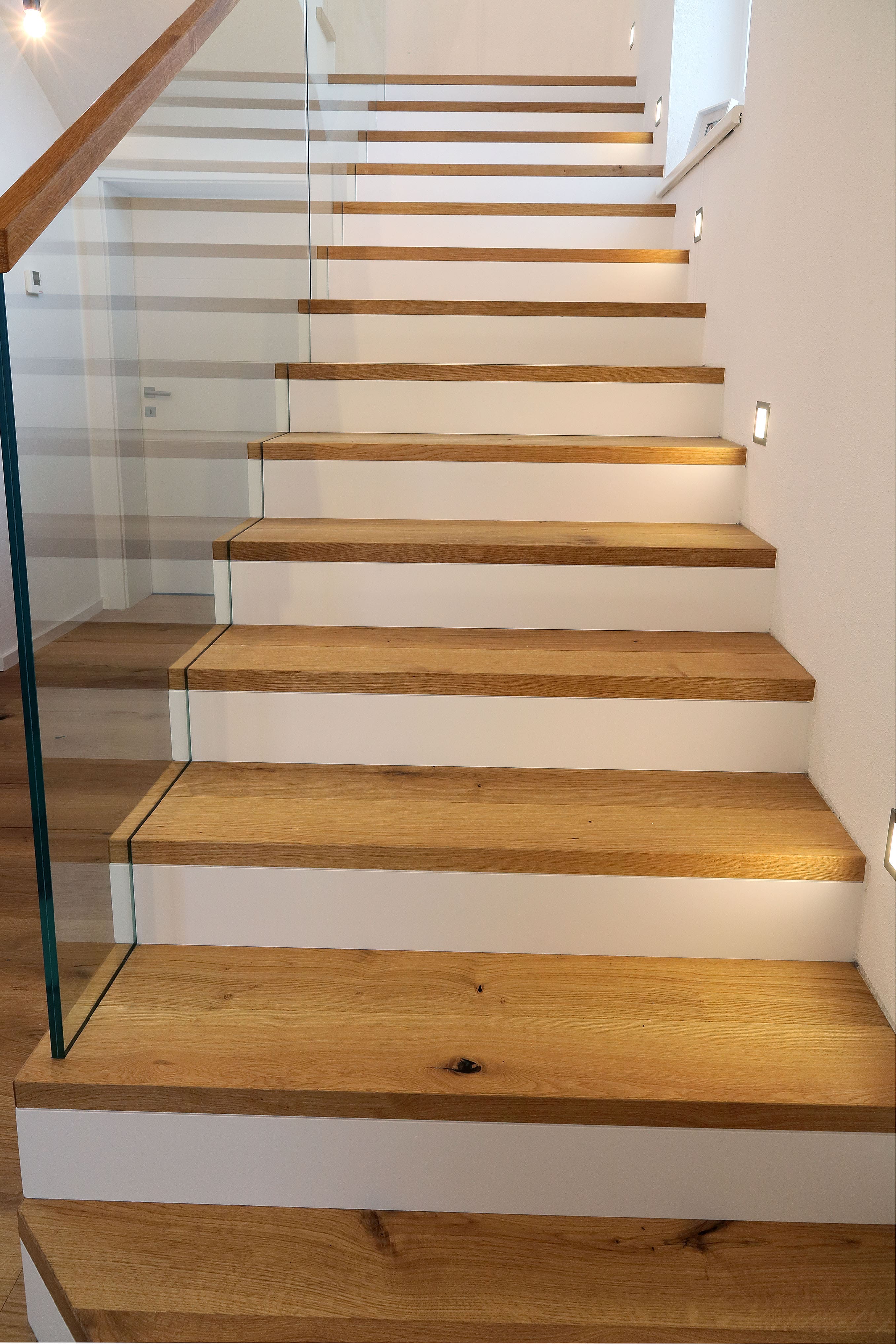 Moderne Holztreppe mit weißen Setzstufen und Glasgeländer - Bild 2