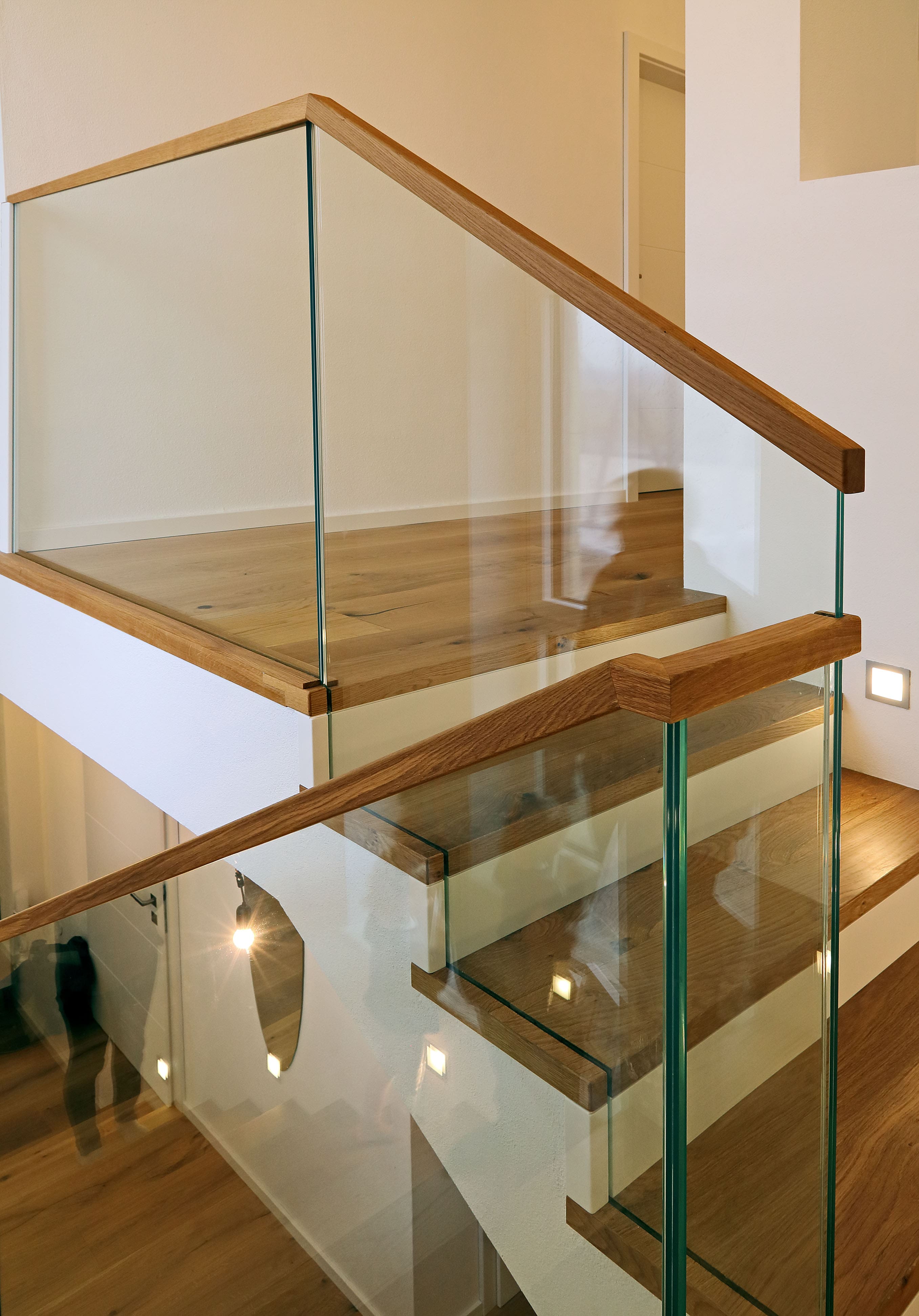 Moderne Holztreppe mit weißen Setzstufen und Glasgeländer - Bild 3